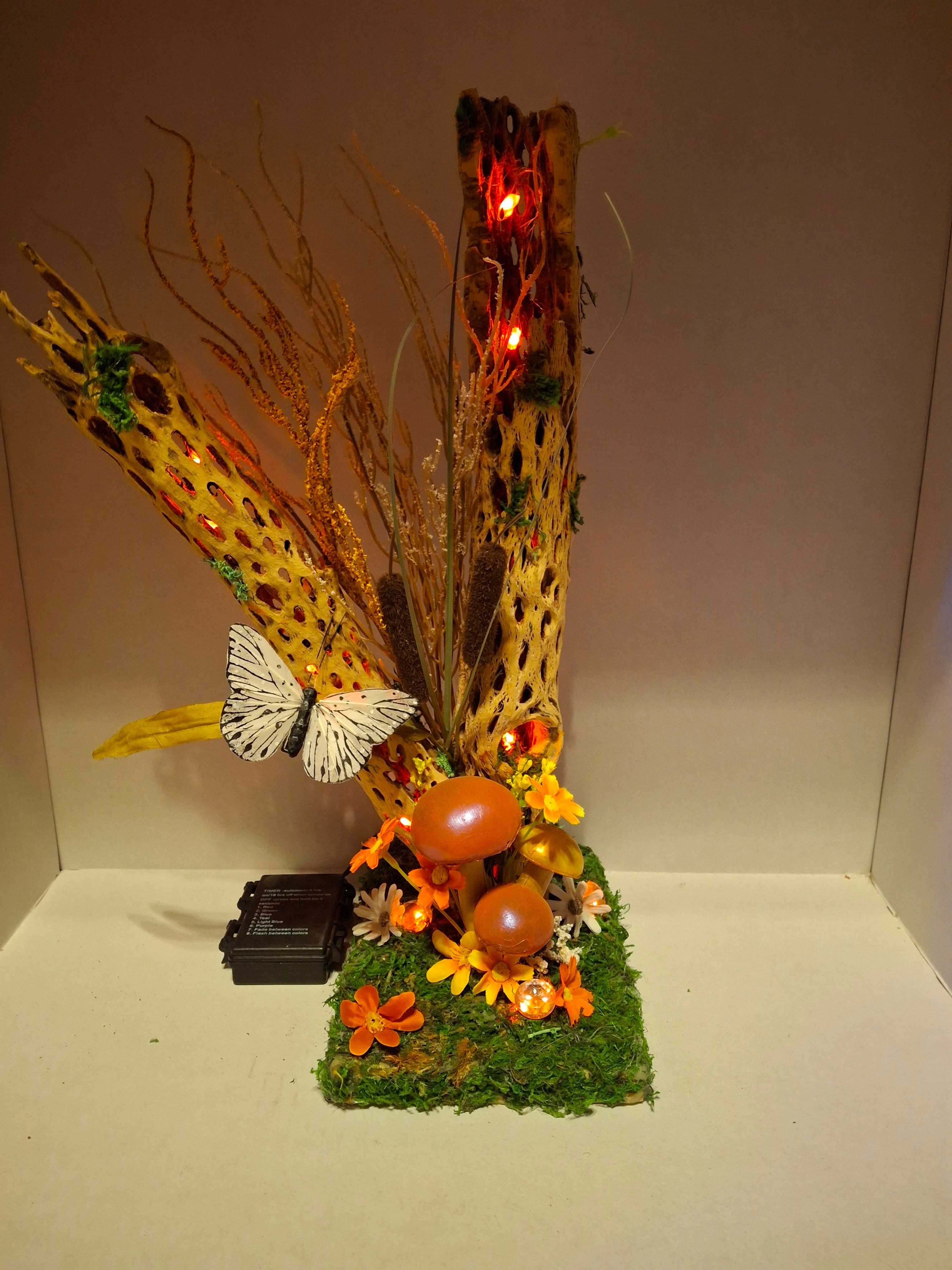 Decorative arrangement with a large fish, flowers, and greenery on a white background.
