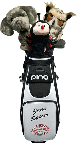 Golf bag with two plush dog toys and a plush ladybug toy on top, with the name Jane Spicer on the bag.